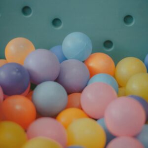 A close-up view of a colorful assortment of plastic balls in a ball pit, showcasing vibrant hues.